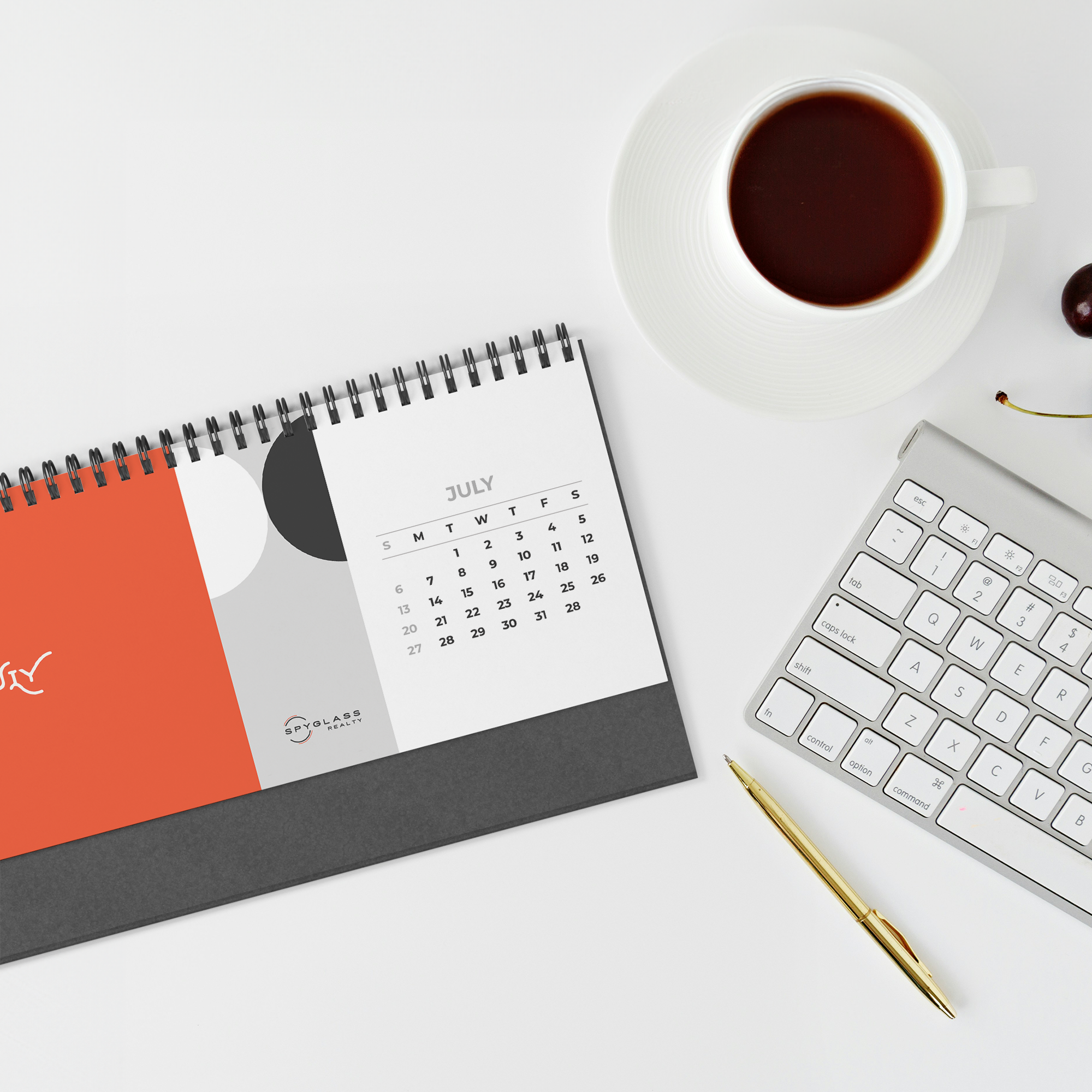 2026_Spyglass_Realty_Desk_Calendar_White_Table_Overhead_Mockup.png